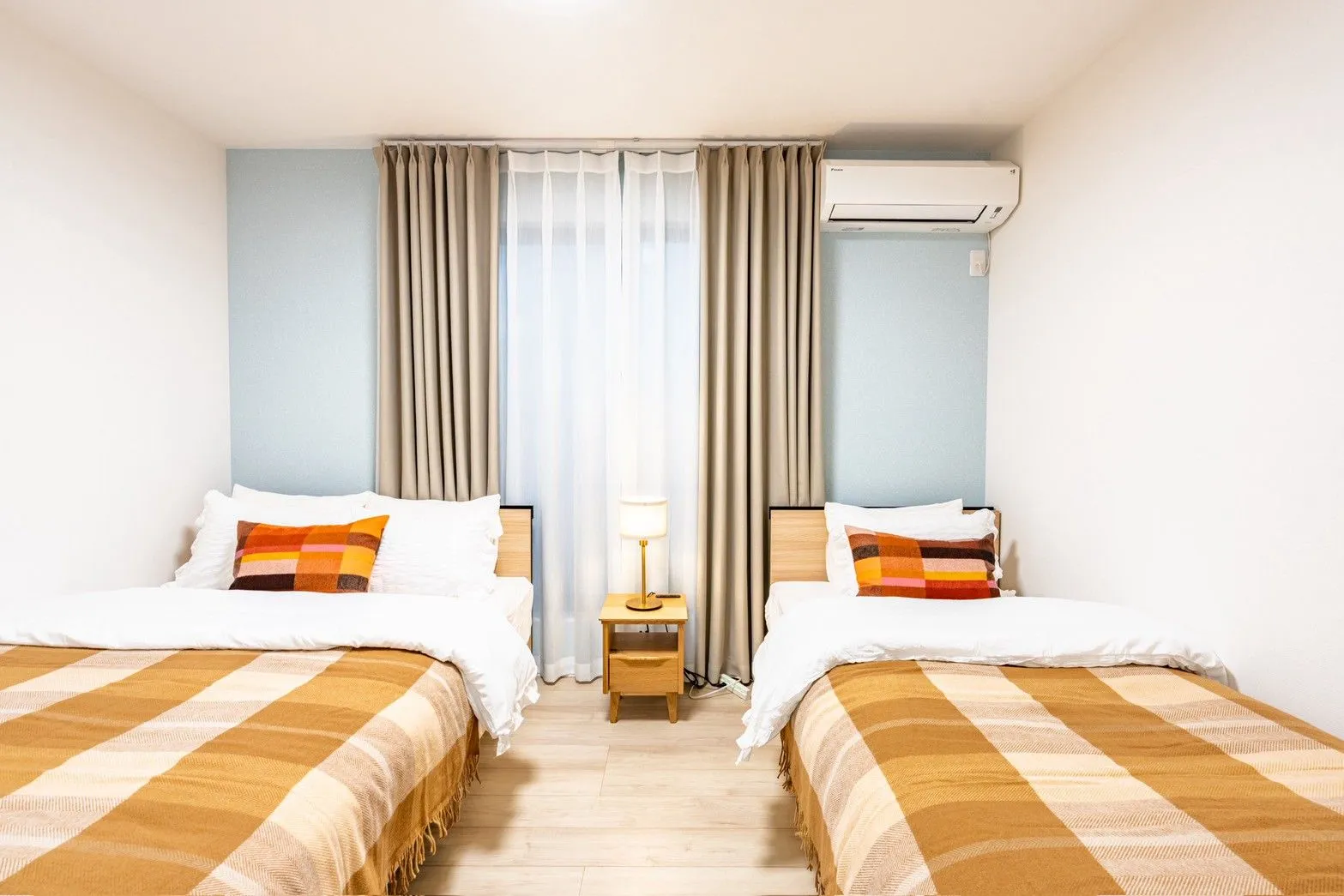 Blue-accent bedroom with one double and one single bed