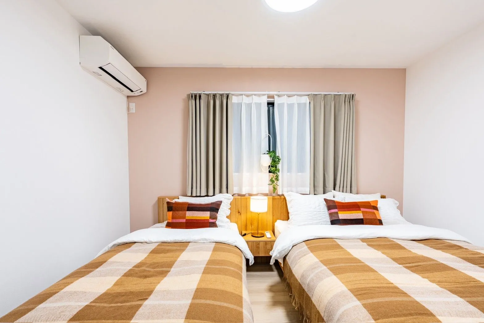 Pink-accent bedroom with one single and one double bed